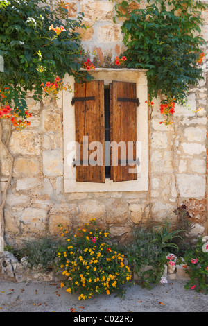 Altes traditionelles Steinhaus in Dalmatien mit Holzfenster und Blumen. Komiza Stadt in Insel Vis. Stockfoto