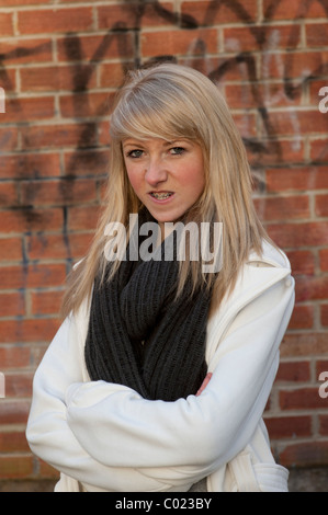 Ein wütend vierzehnjährigen Mädchens stehend mit ihren Armen gefaltet, UK Stockfoto