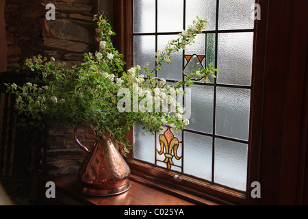 Blume-Anzeige in Messing Vase auf Fensterbank Stockfoto