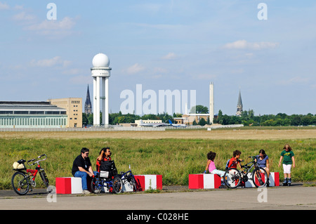 Radfahrer und Kinder sitzen auf den Bänken auf dem Gelände des ehemaligen Flughafens Tempelhof, Park eröffnet im Jahr 2010 auf Tempelhofer Feld Stockfoto
