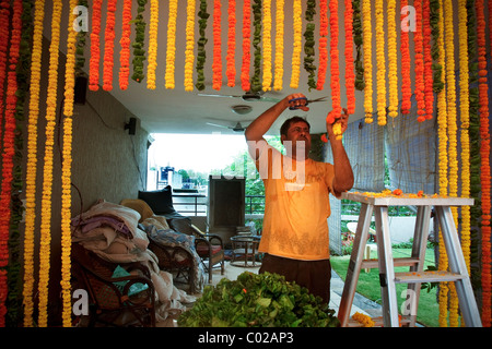 Ein Mann bereitet Blumenornamente vor einer indischen Hochzeit in Neu-Delhi in Indien. Stockfoto