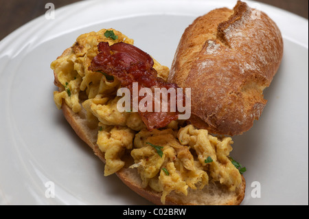 Rührei mit gebratenem Speck auf einem rustikalen Rollen Stockfoto