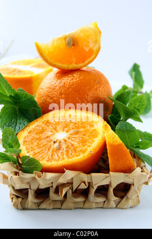 Segmenten Orange und orange und Minze in einem Weidenkorb Stockfoto