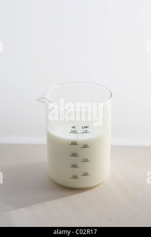 Messbecher mit Milch Stockfoto