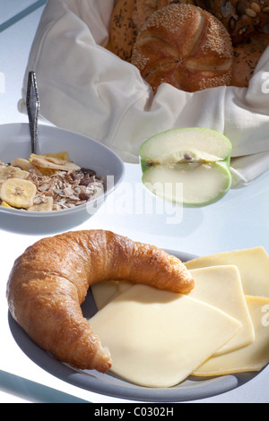 Eingestellten Frühstückstisch mit Kaffee, Brötchen, Müsli und Apfel Stockfoto