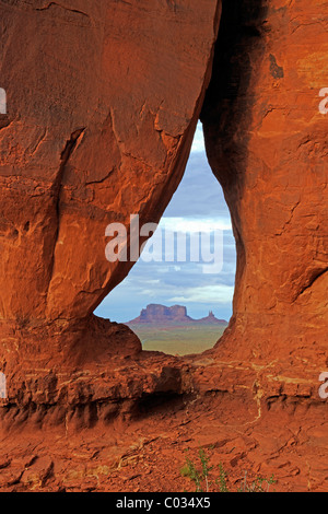 Blick durch den Tear Drop Bogen in Richtung der Tafelberge im Monument Valley, Arizona, USA Stockfoto