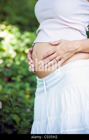 Schwangere Frau in weißem Kleid Stockfoto