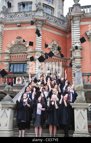 Graduierenden werfen ihre Mörtel-Boards in der Luft bei einer Abschlussfeier an der Royal Holloway University Egham Surrey Stockfoto