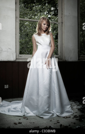 Junge Frau in einem Hochzeitskleid mit langen Schleier in innerstädtischer Lage Stockfoto