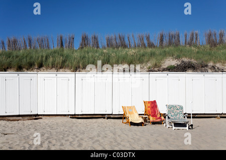 Drei unbesetzte Sonnenliegen mit Handtüchern vor weißen Strand Hütten, Halbinsel Walcheren, der Provinz Zeeland, Niederlande, Benelux Stockfoto