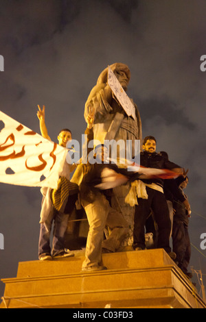 Ägyptischen Demonstranten feiert Sieg in der Revolution auf dem Tahrir auf Statue von Omar Makram Stockfoto