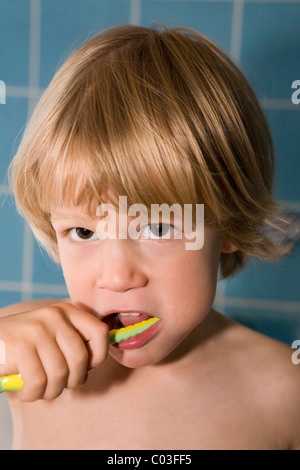 Vier-jährige blonde Junge, der seine Zähne putzen Stockfoto