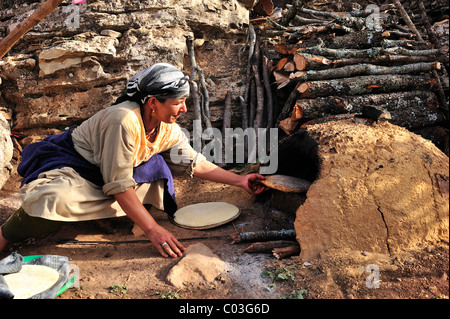 Ältere Frau Backen Pita-Brot in einem Lehmofen, mittleren Atlas, Marokko, Afrika Stockfoto