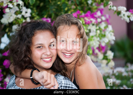 Porträt von zwei 13-jährige Mädchen vor Blumen Stockfoto