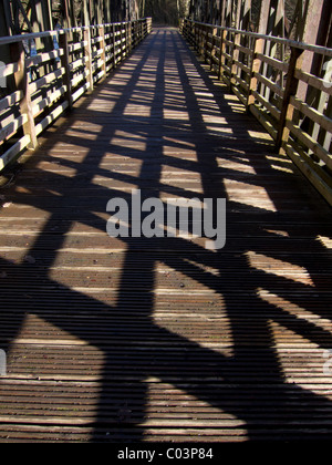 Schatten auf einer Holzbrücke, Teil der ehemaligen Penrith Keswick-Eisenbahnlinie, die jetzt als ein Fußweg von Touristen genutzt. Stockfoto