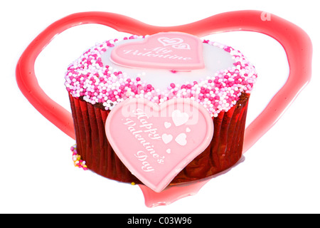 Tasse Kuchen zum Valentinstag mit Marzipan Herzen vor, Perlen auf Top und Erdbeer Herz im Hintergrund Stockfoto