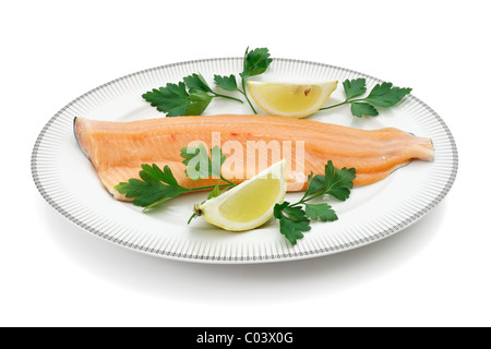 Platte mit Lachs und Forellenfilet, Petersilie und Zitrone isoliert auf weiss mit Beschneidungspfad Stockfoto