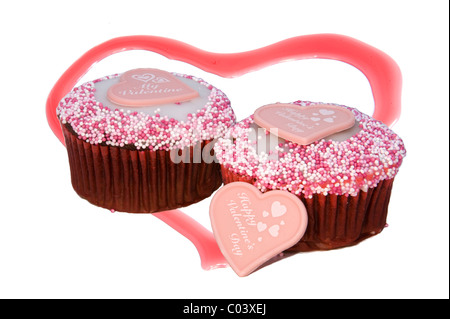 Tasse Kuchen zum Valentinstag mit Marzipan Herzen vor, Perlen auf Top und Erdbeer Herz im Hintergrund Stockfoto