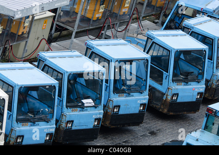 Reihe von Gepäck Traktoren auf einem Flughafen Parken Stockfoto