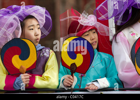 Zwei junge Mädchen in traditionellen Kostümen und halten Fans fahren auf einem Floß an der 2011 Lunar New Year Parade in Flushing, Queens Stockfoto