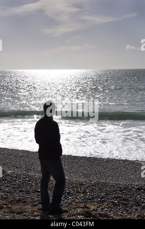 Ein junger Mann stand auf einer sonnigen Meer Strand Stockfoto