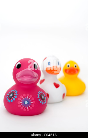 Drei farbenfrohe Gummienten auf weißem Hintergrund Stockfoto