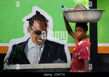 Eine Frau umgeht ein Straße Wandbild in der Stadt von Marmelade, Haiti. Stockfoto