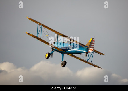 Ein Vintage PT13-D Stearman Doppeldecker fliegen an Compton Abbas Flugplatz in England Stockfoto