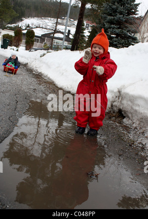 Kinder spielen im Schlamm im zeitigen Frühjahr Stockfoto
