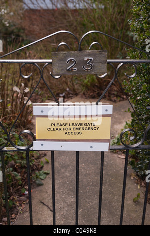 Ein Schild an einer britischen Tor lesen lassen bitte Tor klar für Notfälle Stockfoto