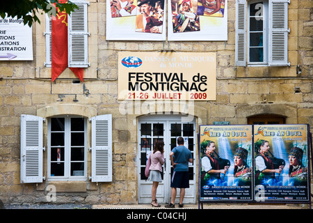 Jugendliche lesen Festivalposter über Festival de Montignac in der Dordogne, Frankreich Stockfoto