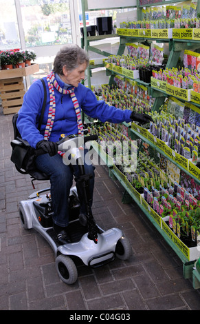 Mobilität Roller Nutzer Reiten eine ultra leichte batteriebetriebene Maschine in ein Gartencenter der Maschine ist Selbstmontage Stockfoto