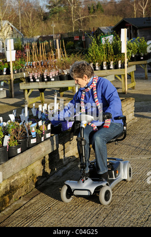 Mobilität Roller Nutzer Reiten eine ultra leichte batteriebetriebene Maschine in ein Gartencenter der Maschine ist Selbstmontage Stockfoto