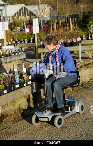 Mobilität Roller Nutzer Reiten eine ultra leichte batteriebetriebene Maschine in ein Gartencenter der Maschine ist Selbstmontage Stockfoto