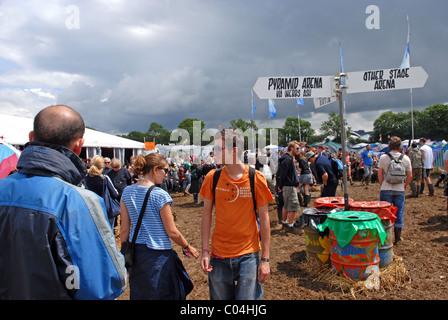 Festivalbesucher geht durch den Schlamm beim Glastonbury Festival, Somerset, Großbritannien Stockfoto