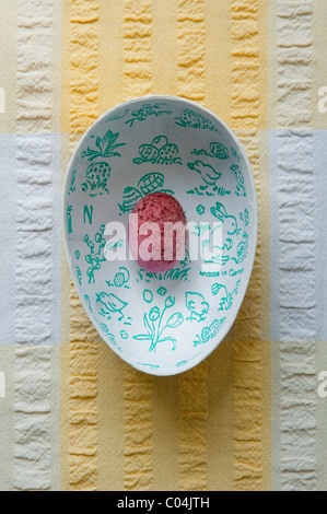 Einzigen rosa Süßigkeiten bedeckt Mini Schokoladeneier in eiförmigen Box mit Ostern Bilder im Inneren. Stockfoto
