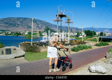 Unabhängige älterer Senior Mann zu Fuß mit Walker, Osoyoos, BC, Britisch-Kolumbien, Kanada - Pionier Gehweg neben Osoyoos Lake Stockfoto