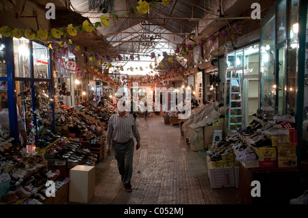 Ein kurdischer Ladenbesitzer, der durch den Marktbasar in der Stadt Erbil in der Autonomen Region Kurdistan im Nordirak läuft. Stockfoto