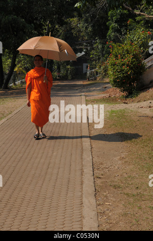 Mönch hält Regenschirm für den Schatten von Mittagssonne, Kam Ko Tempel Wat, Mae Hong Son, thailand Stockfoto