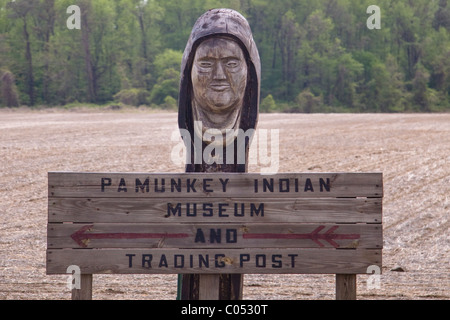 Hölzerne Totempfahl und Pamunkey Indian Museum und Handelsposten Richtungsanzeiger in der Nähe eines gepflügten Felds bei ihrer Reservierung in VA. Stockfoto
