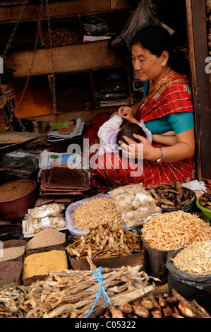 nepalesische Frauen kümmert sich um ihr Baby und auf der Suche nach ihrem Kräuter- und Gewürz-Shop Völker Leben (die Nepalesen), Kathmandu, nepal Stockfoto