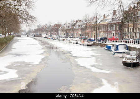 Kanal mit Booten in niederländischen Stadt im Winter eingefroren. Stockfoto