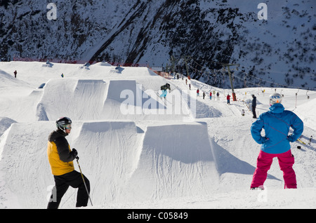 Snowboarder und Skifahrer über Sprungschanzen in Stanton Park Funpark am Rendl. St. Anton am Arlberg, Tirol, Österreich, Europa. Stockfoto