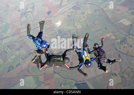 Vier Fallschirmspringer im freien Fall Formationen zu tun Stockfoto