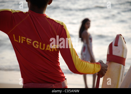 Ein Rettungsschwimmer und eine Schönheit Augen gegenseitig an einem Strand in Goa Stockfoto