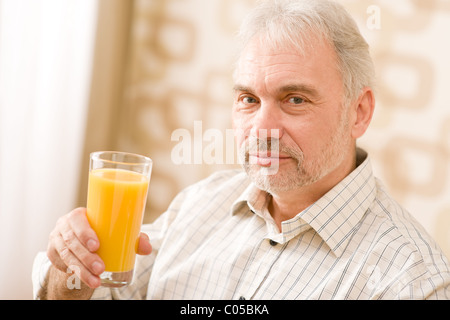 Senior reifer Mann mit Glas Orangensaft Stockfoto