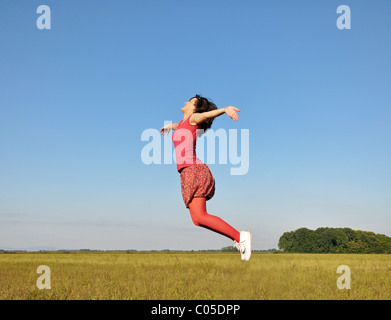 Junge Frau, die hoch in die Luft springen Stockfoto