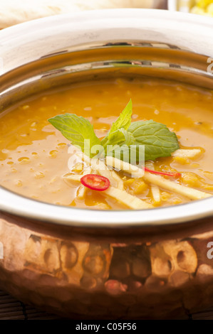 Linsensuppe in einer Messing-Schüssel mit Reis im Hintergrund Stockfoto