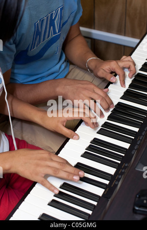 Hispanische High-School-jungen und Mädchen spielen im Musikunterricht Klavier an Mission Early College High School in El Paso TX Stockfoto