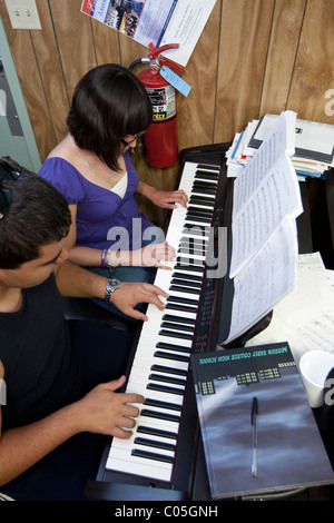 Hispanische High-School-jungen und Mädchen spielen im Musikunterricht Klavier an Mission Early College High School in El Paso Texas USA Stockfoto